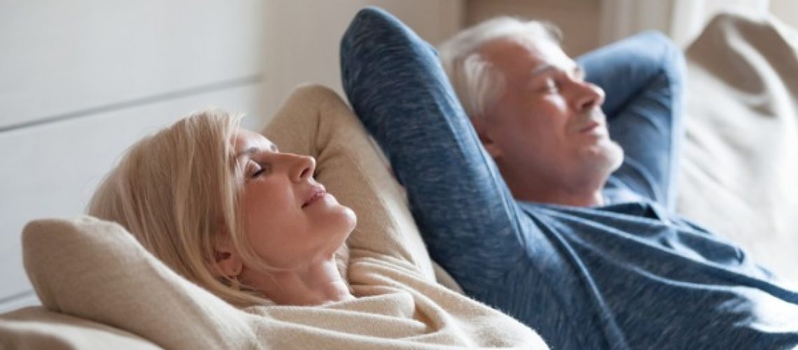 calm-mature-couple-relaxing-on-sofa-having-daytime-nap-together-picture-id1049512746